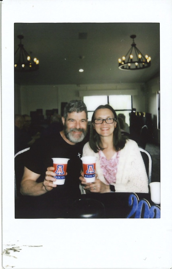 Instax of a couple at a party with U of A cups